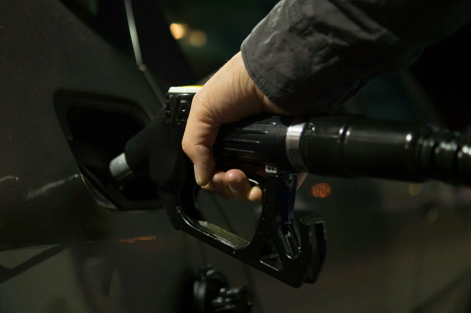 Man holding a nozzle and pouring premium fuel at a Tropical Oil location in Florida.